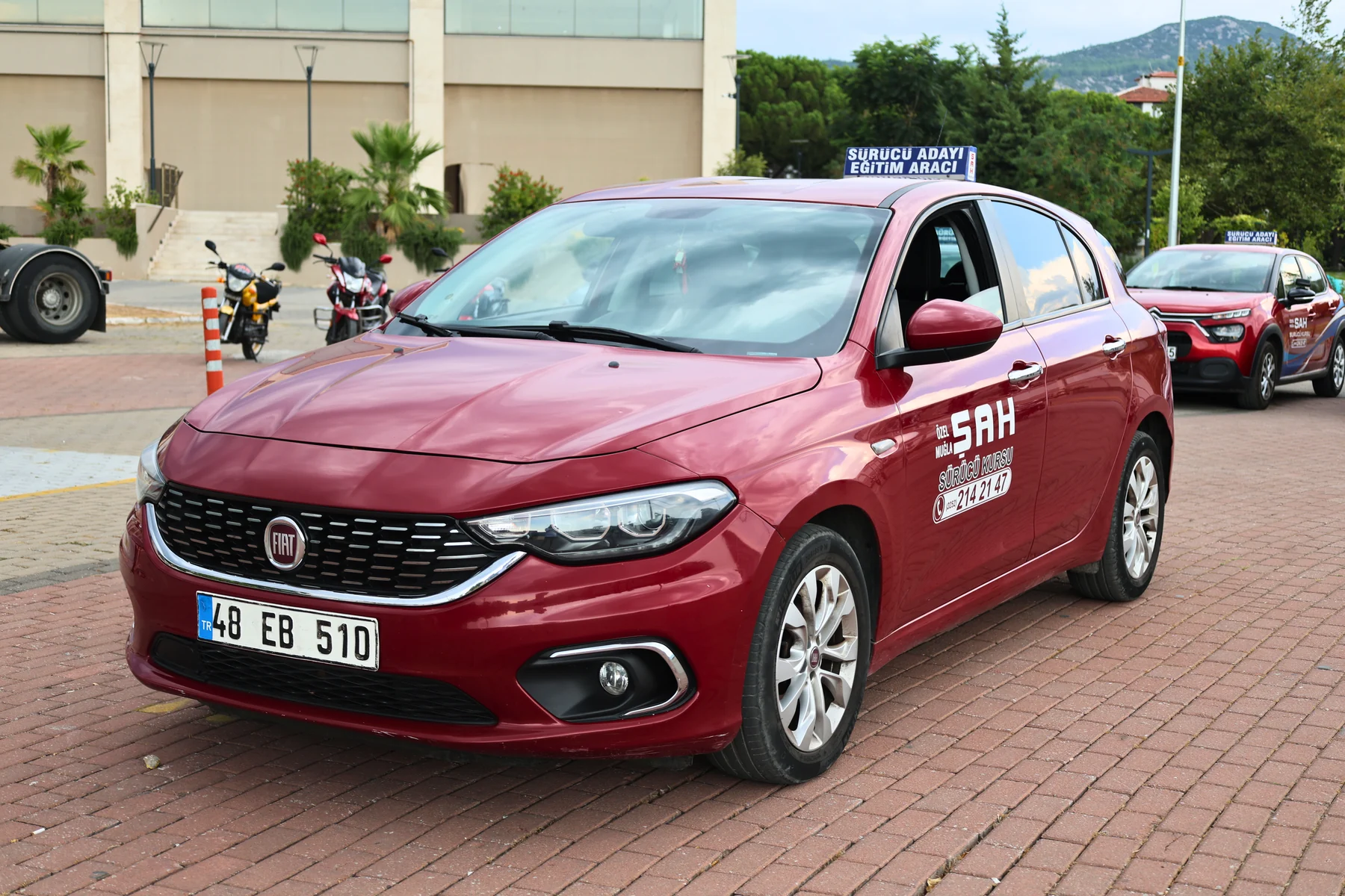 A red Fiat driver-training car from Şah Driving School