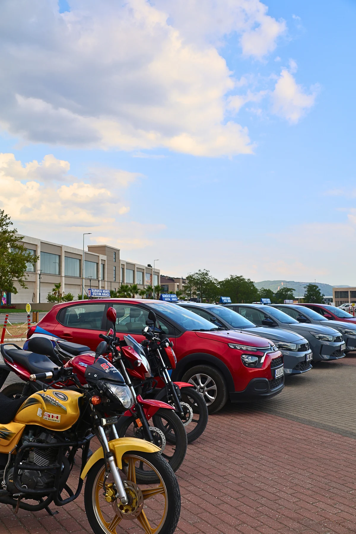 Şah Driving School motorcycle and car training vehicles side by side